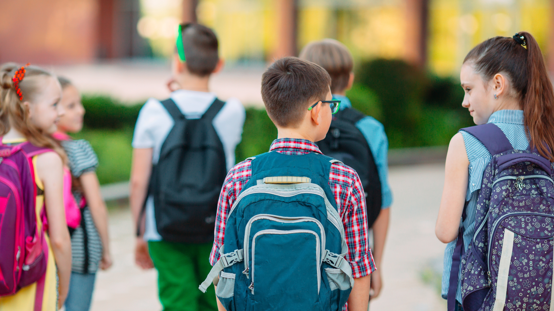 Children walking together with backpacks