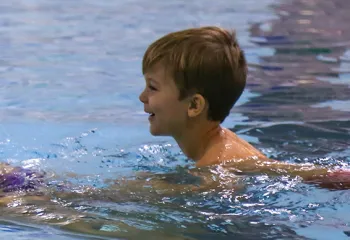 instructor in water with young child