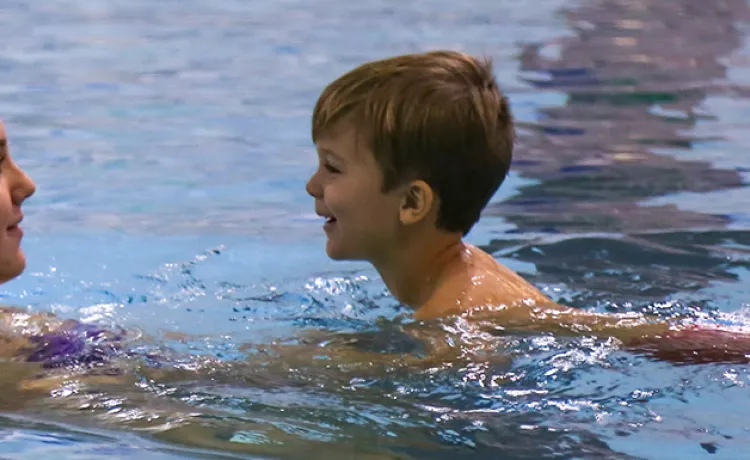 instructor in water with young child