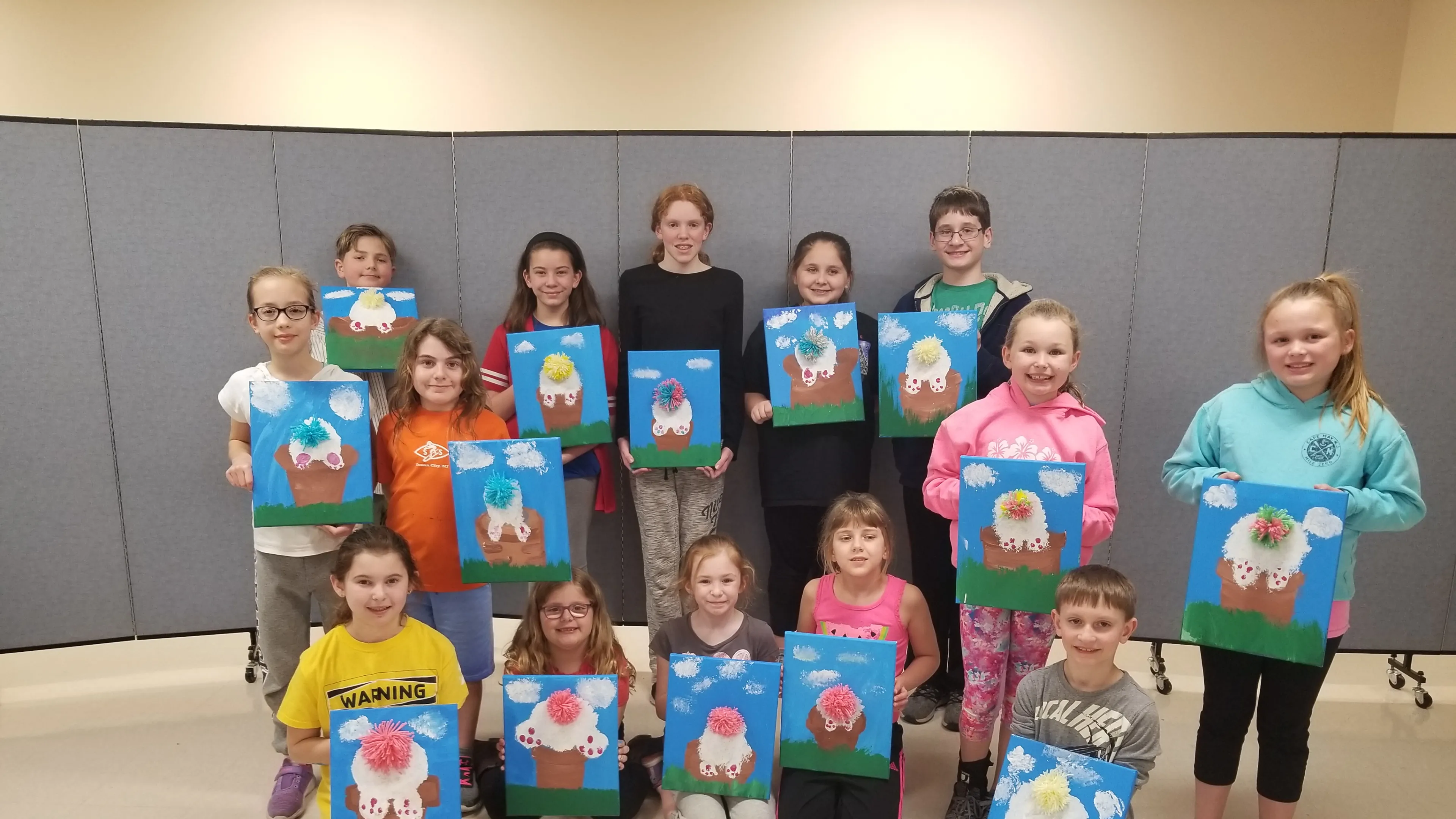 group of youth holding paintings