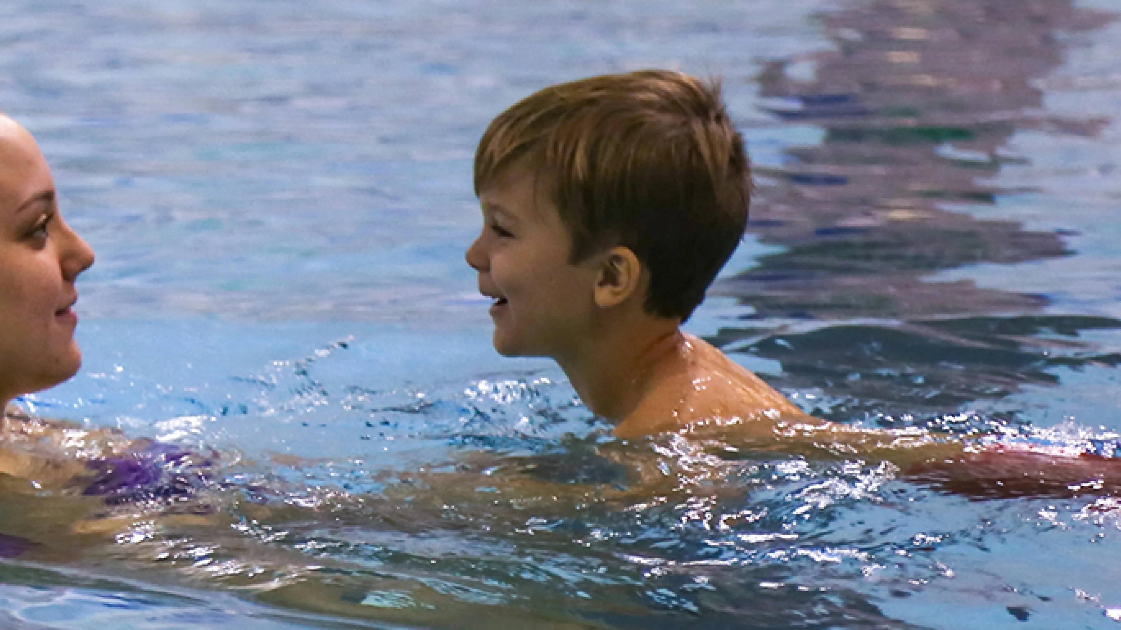 instructor in water with young child