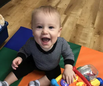 baby playing with toy on floor