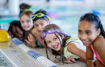 kids smiling in water swim lesson
