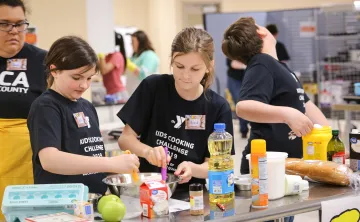teens baking at counter while instructor looks on