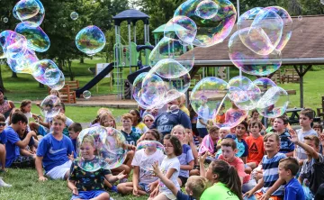 campers watch large bubbles